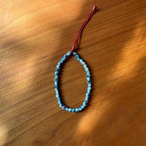 Artisanal handmade god’s eye bracelet on red cord